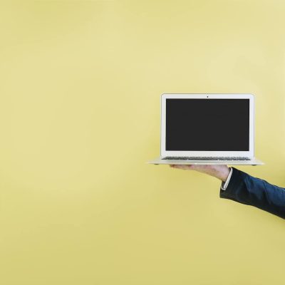 crop-hand-showing-laptop-yellow